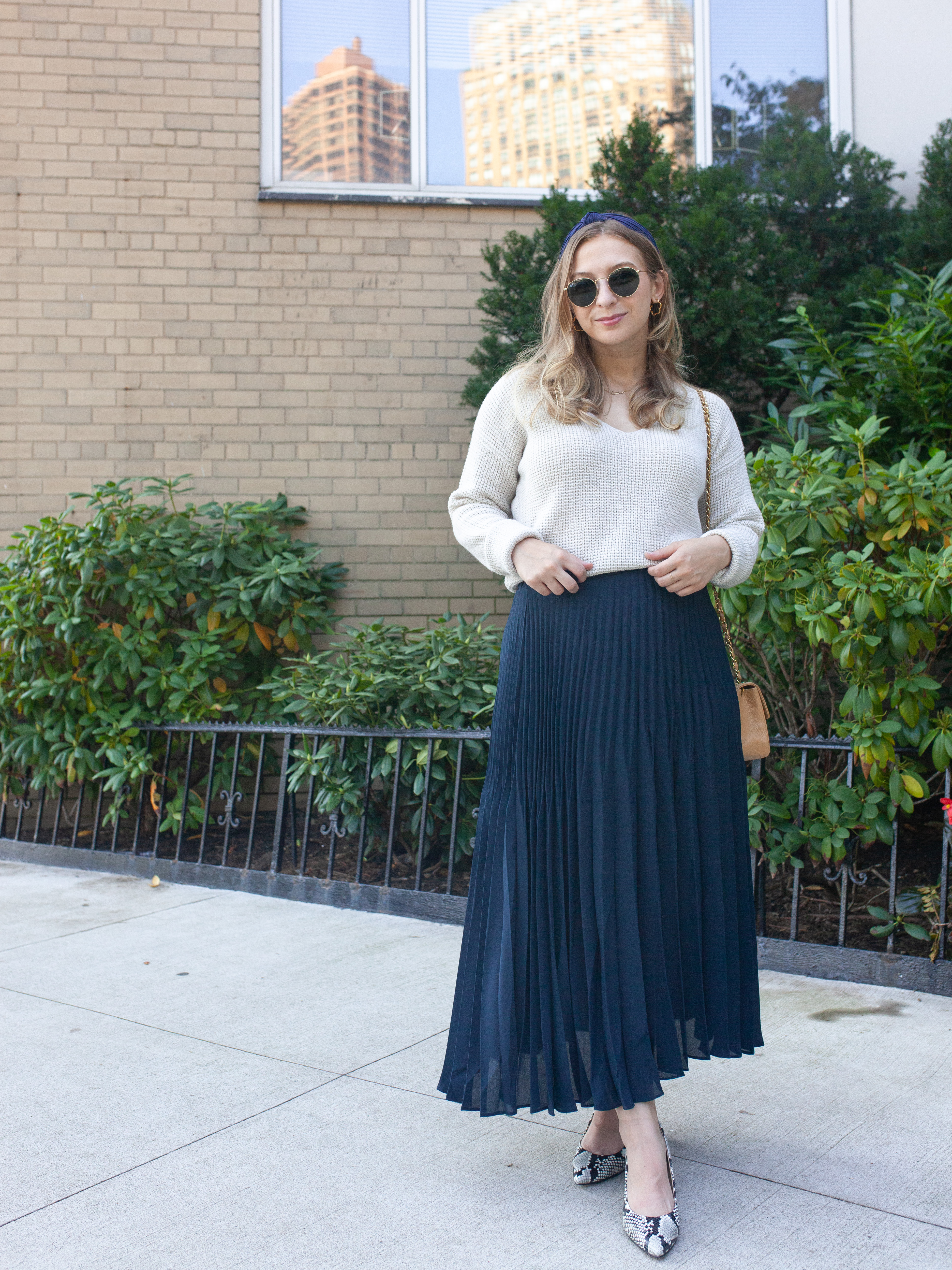 girl with blonde hair wearing navy blue maxi skirt, snakeskin high heels, oatmeal sweater and sunglasses