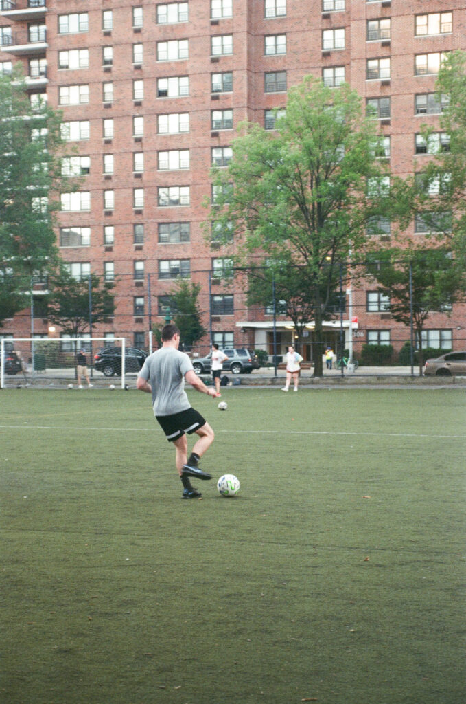 man playing soccer on a field in new york city shot on film