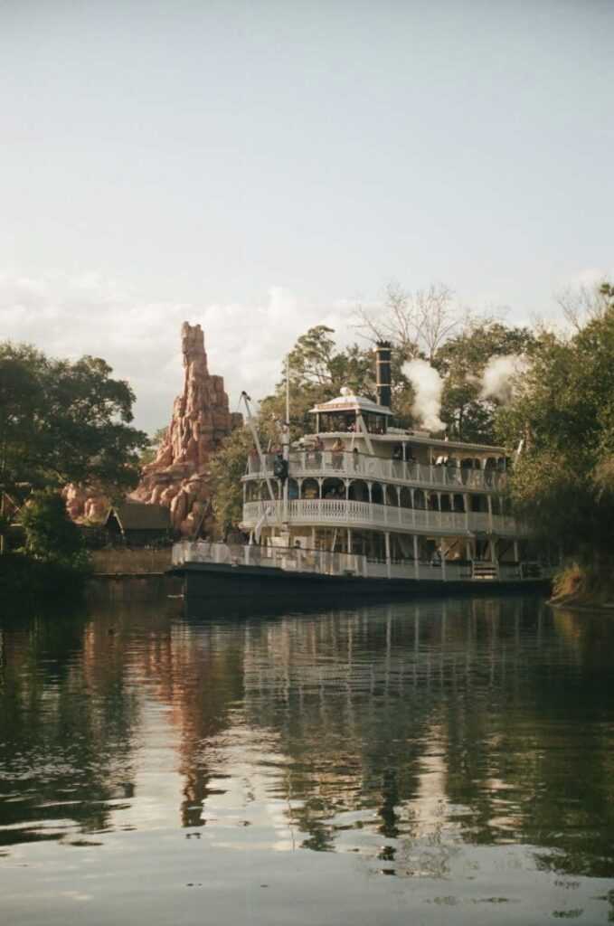 steamboat on the water in front of roller coaster at magic kingdom in walt disney world florida